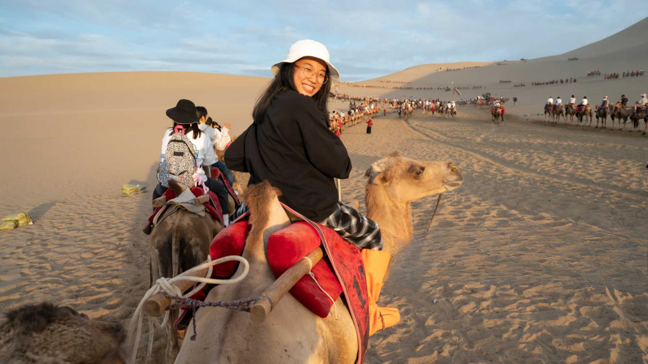 Girl tourist traveling on camel ride in dubai